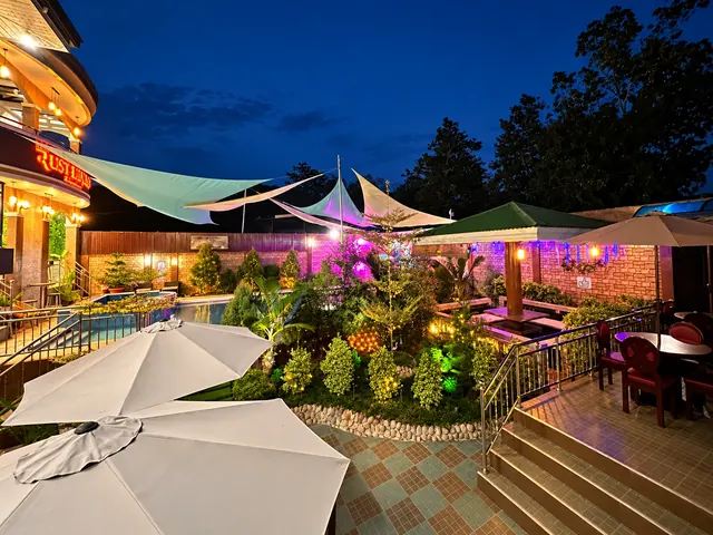 The garden and terrace in the evening, lit with warm lights