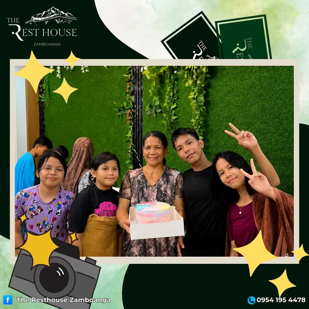 Family members smiling with a birthday cake against the green wall