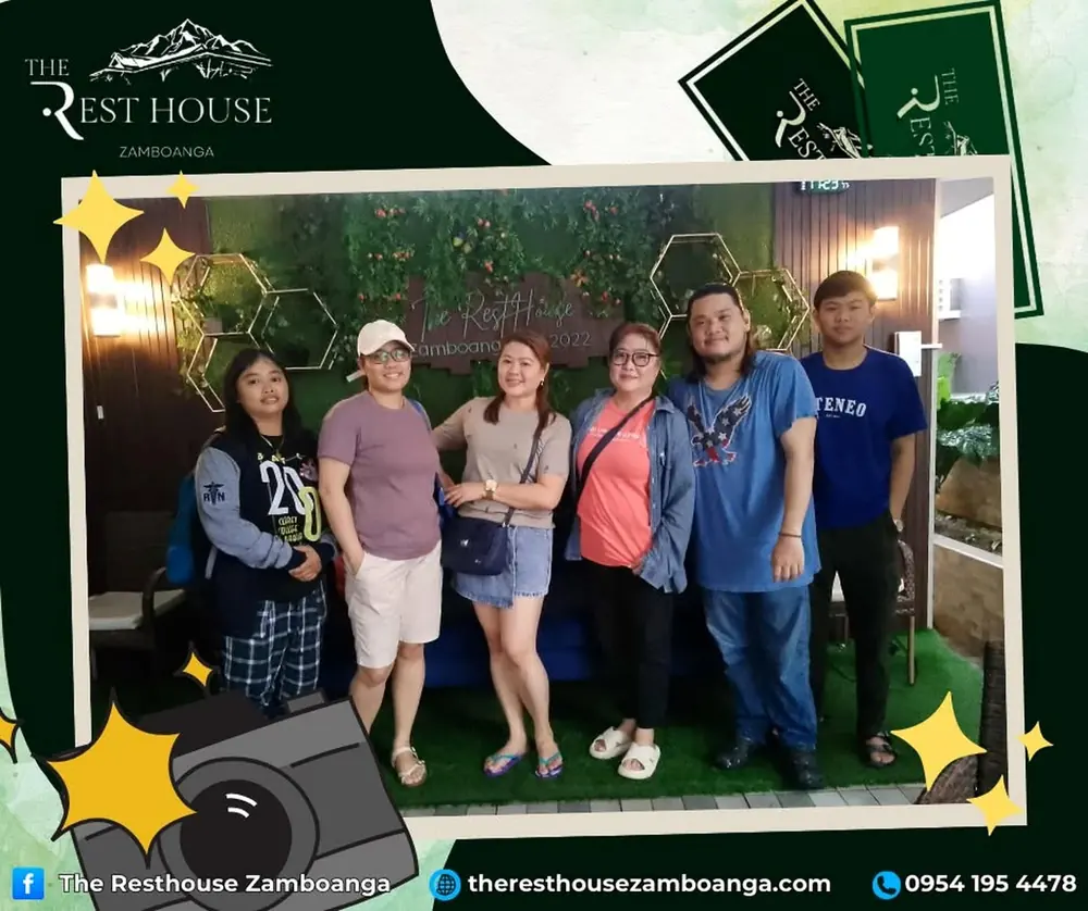 Six friends standing together in front of the resort sign
